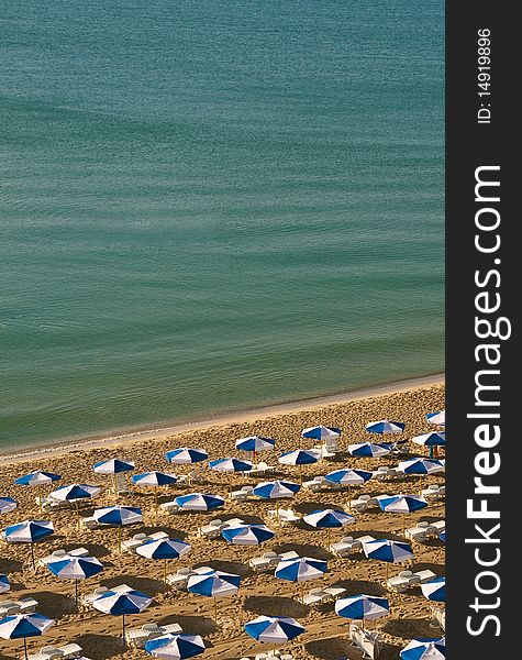 Clean, empty sea coast with umbrellas on the sand. Clean, empty sea coast with umbrellas on the sand.