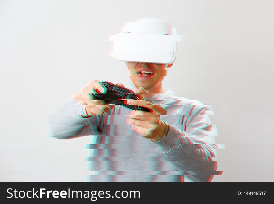 Man with virtual reality headset is playing game. Image with glitch effect.