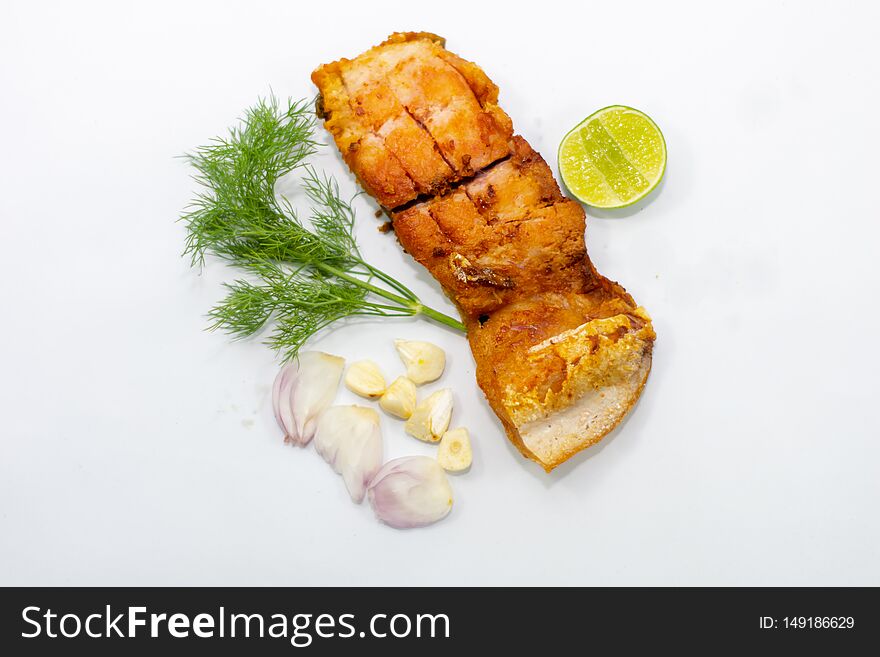 Fried marinated fish fillets with vegetables, onions, garlic on top