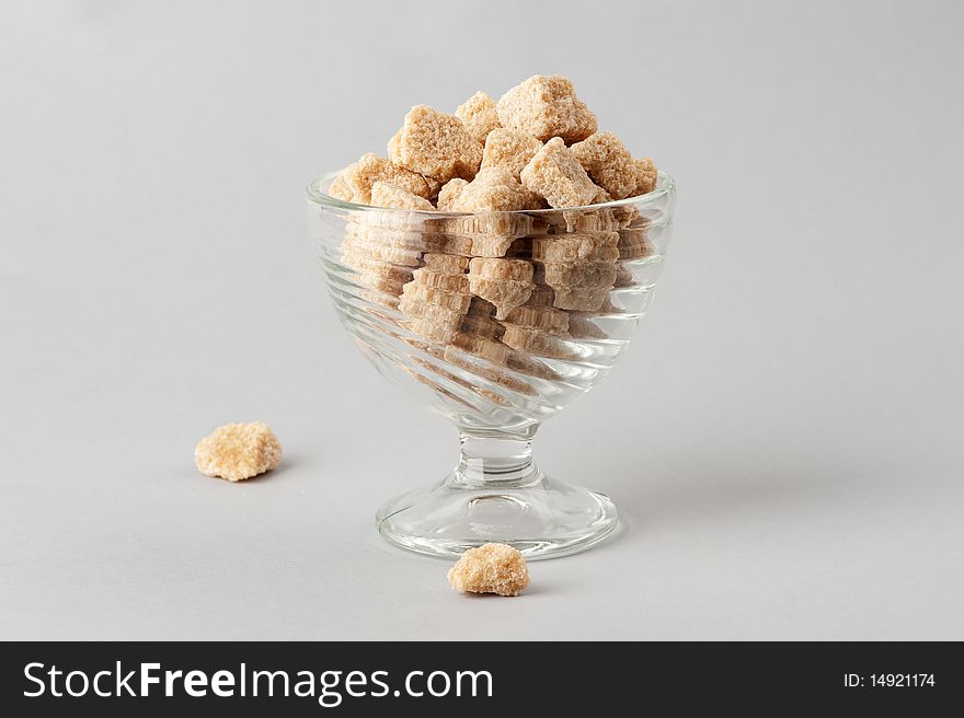 Cane sugar cubes isolated on a gray background