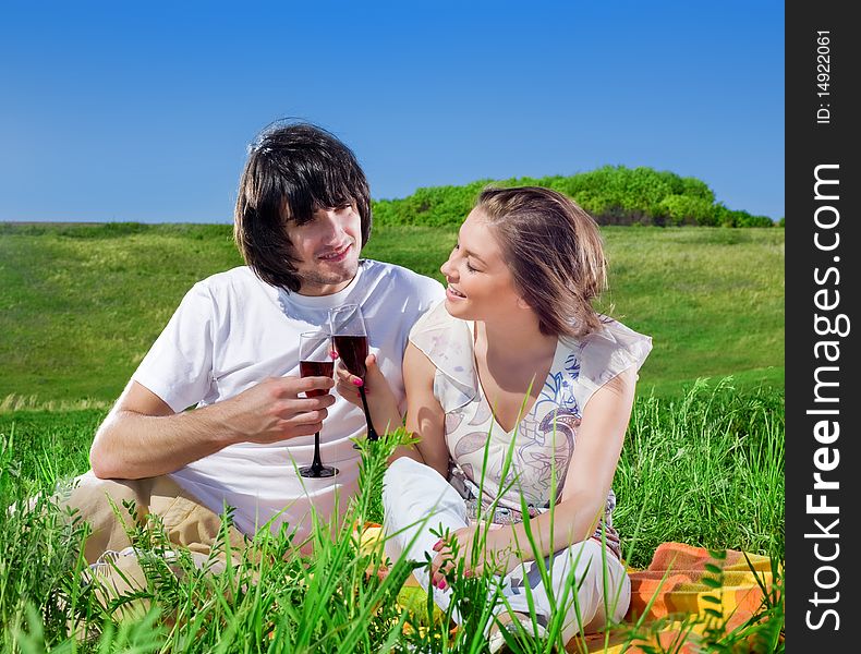 Girl and boy with wineglasses on grass