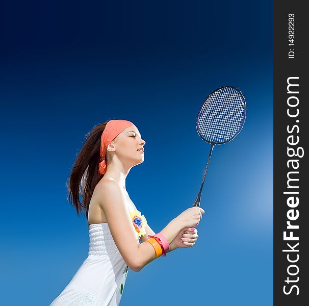 Beautiful girl with racket on blue background