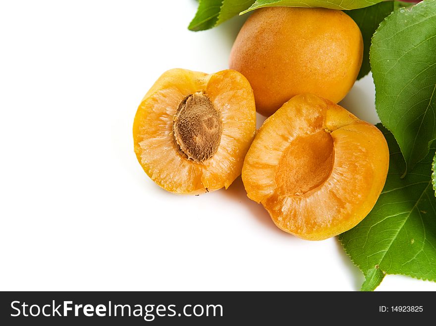 Fresh apricot with green leaves on a white background