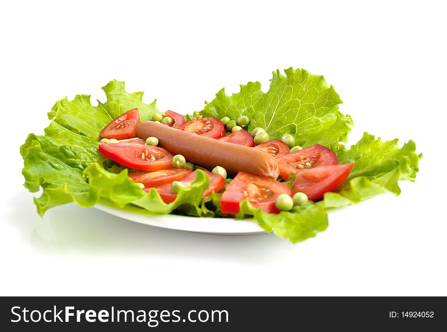 Sausage in a plate on lettuce with peas