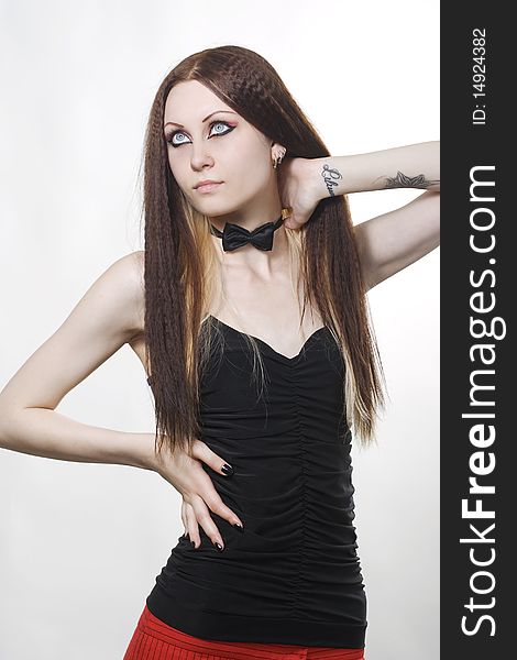 Elegant fashion model with dark make-up posing in studio