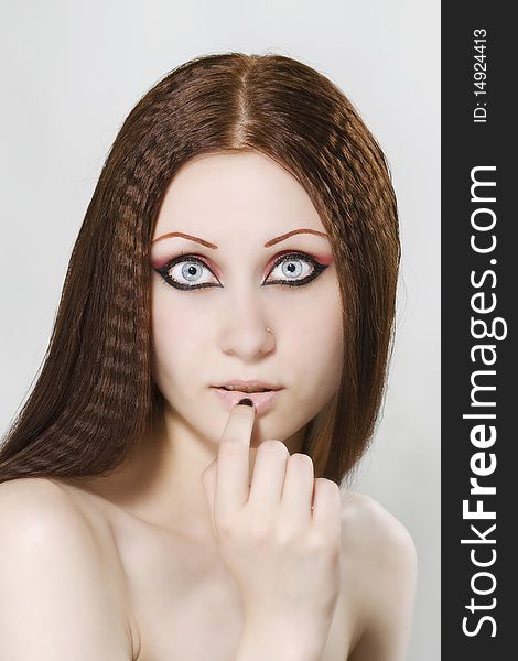 Close-up portrait of a young, beautiful caucasian woman with black nail polish and dark make-up