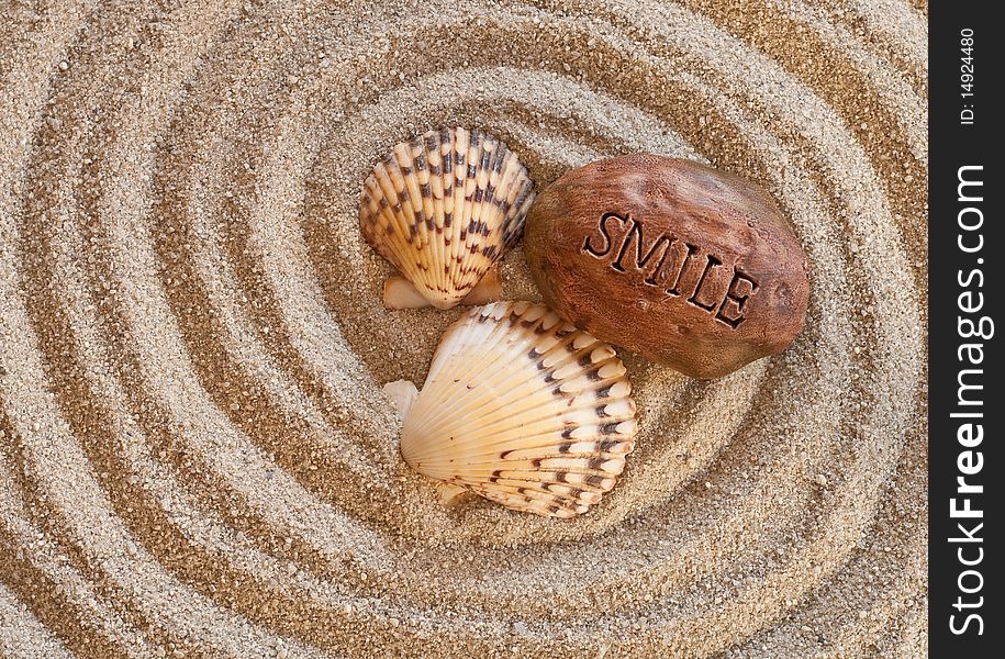 Conceptual image with seashells and a smile stone on sand. Conceptual image with seashells and a smile stone on sand