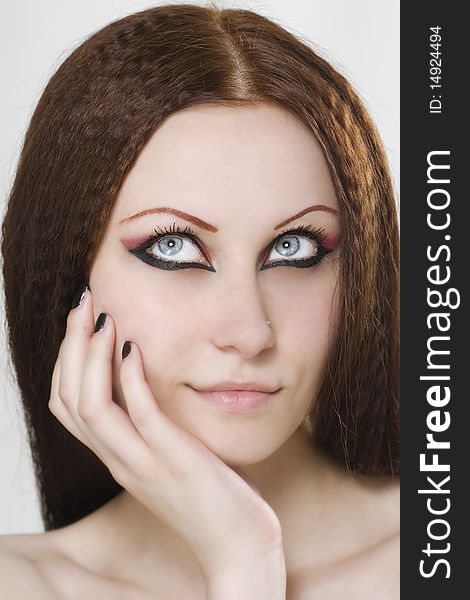 Close-up portrait of a young, beautiful caucasian woman with black nail polish and dark make-up