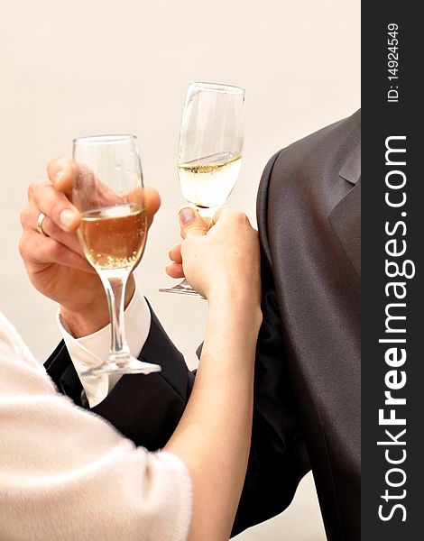 Image of two glasses of champagne in the hand on gray background