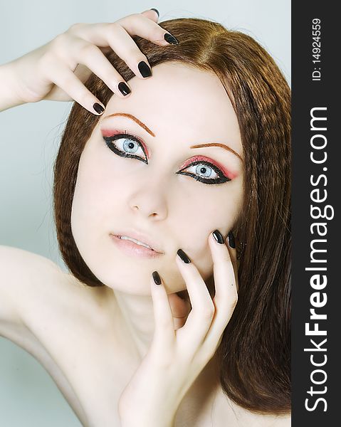 Close-up portrait of a young, beautiful caucasian woman with black nail polish and dark make-up