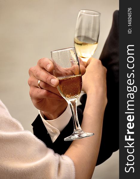 Image of two glasses of champagne in the hand on gray background