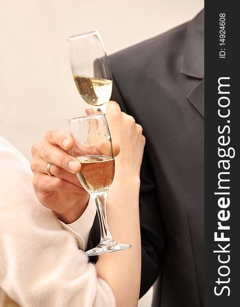 Image of two glasses of champagne in the hand on gray background