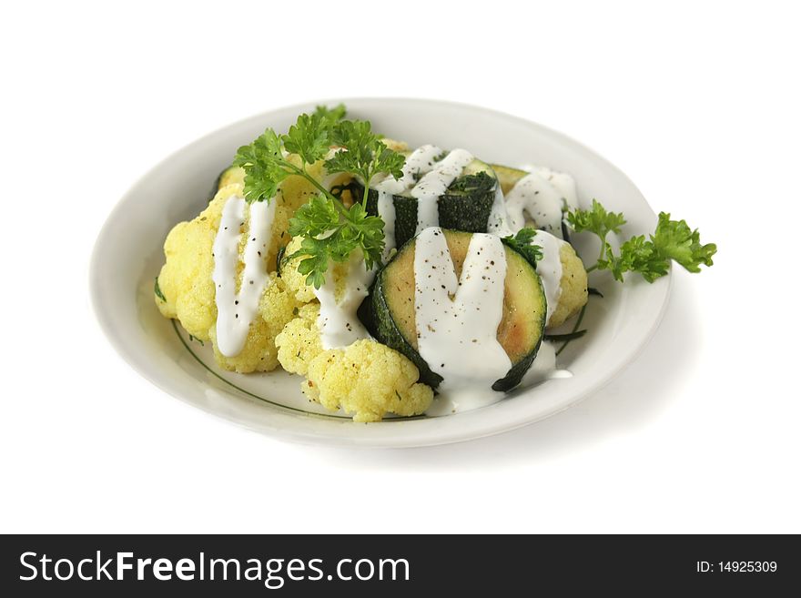 Stewed vegetables with sour cream in a bowl on a white background