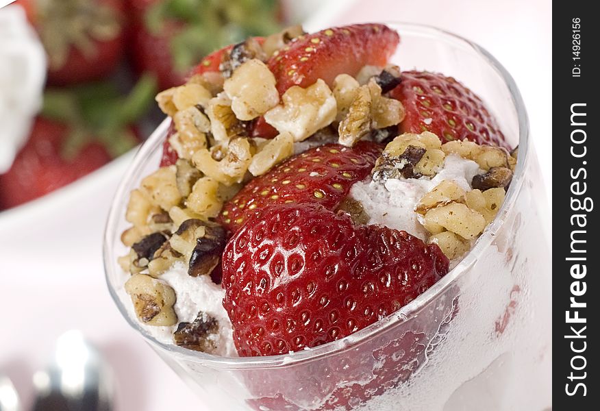 A strawberry glass with some nuts and ice cream viewed from top. A strawberry glass with some nuts and ice cream viewed from top.