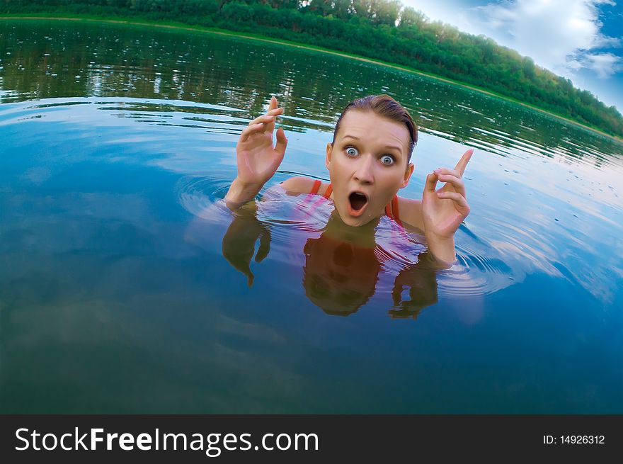 Beautiful young girl with a bright emotions swimming in the river. Beautiful young girl with a bright emotions swimming in the river