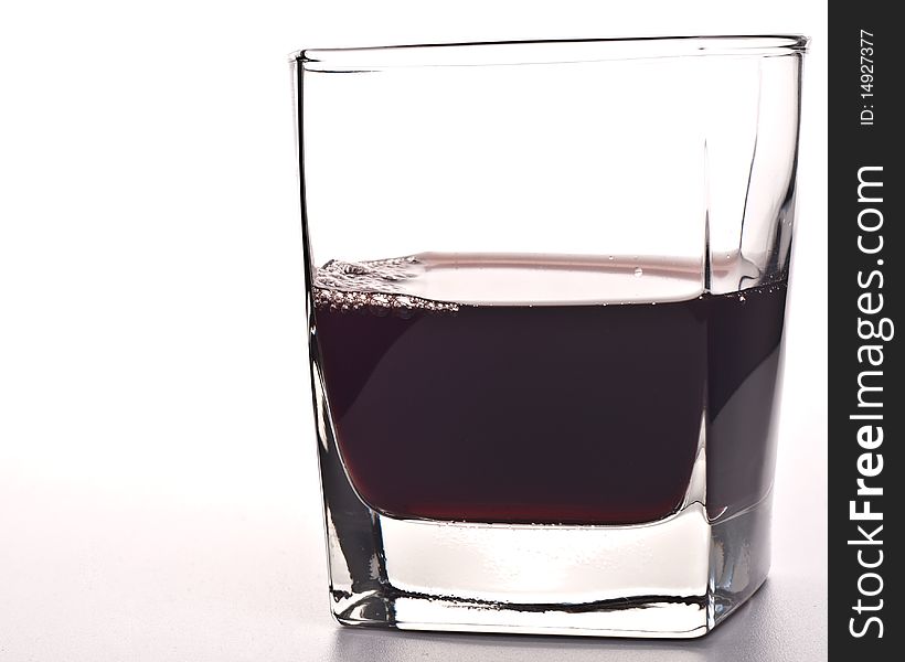 Glass of red drink isolated over white background