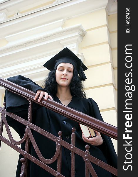 Young student in gown near the university