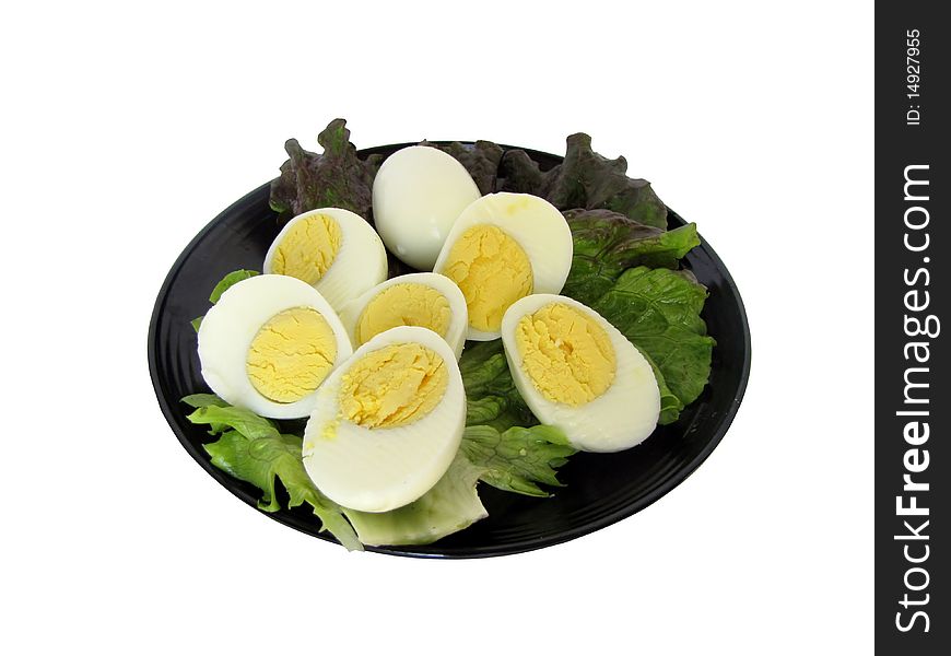 Sliced hard boiled eggs on a leaf of lettuce.