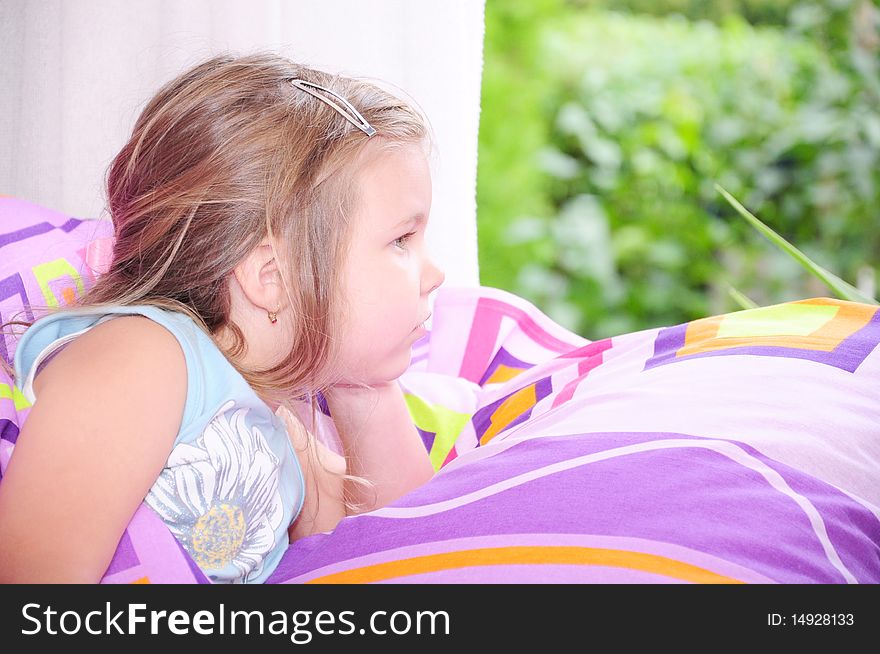 Girl lying in bed looking out the window. Girl lying in bed looking out the window