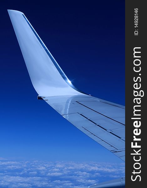 Airplane wing in the sky with blue background stock photo