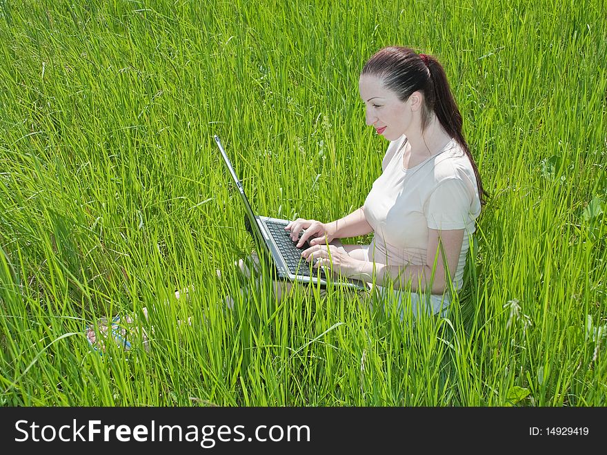 Beautiful girl setting outdoor with laptop summer