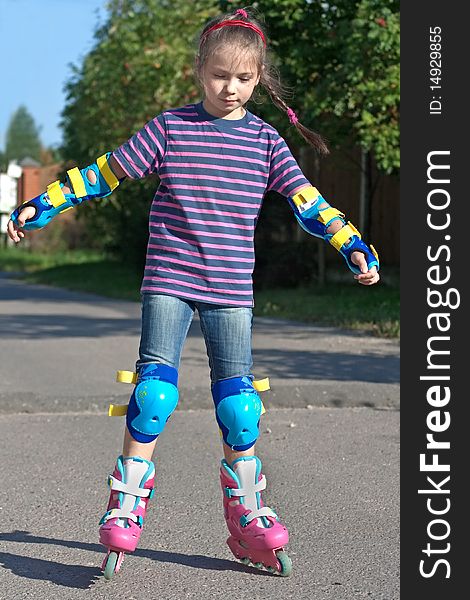 Girl riding on roller blades on summer holidays. Girl riding on roller blades on summer holidays