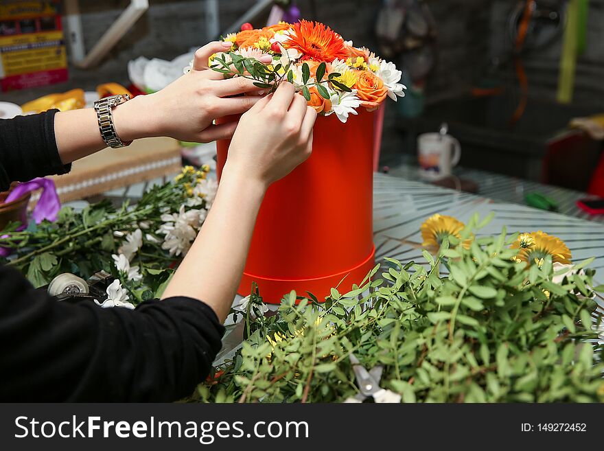 The hands of the florists make a bouquet. woman`s hands make a floral arrangement. florist makes a gift bouquet in a flower shop