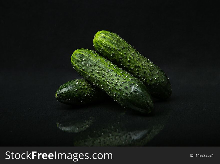 Cucumbers with pimples isolated on a black background with reflection