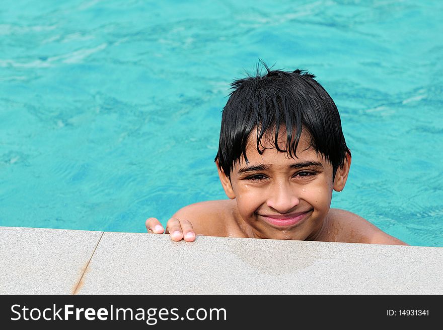 A handsome Indian kid playing in the pool