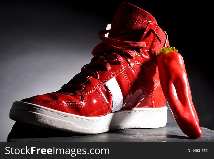 Red shoe and pepper on a black background. Red shoe and pepper on a black background