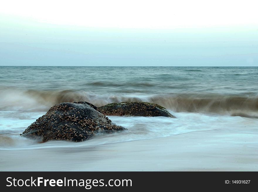 Stormy waves hitting rock on a tropical beach