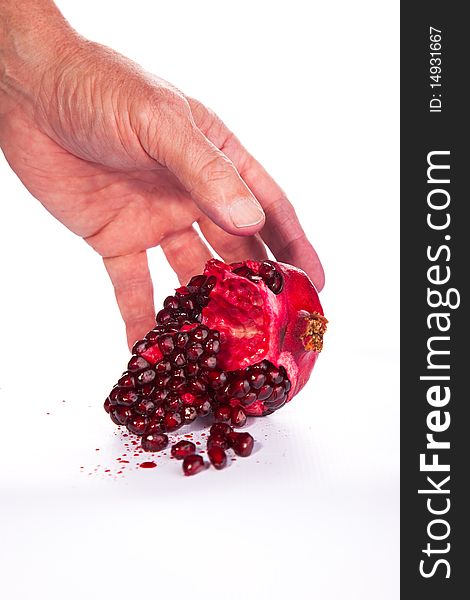 Image of a Pomegranate being picked up by hand