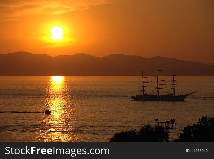 Yacht in gulf, mountains on background, sunset, summer. Yacht in gulf, mountains on background, sunset, summer.