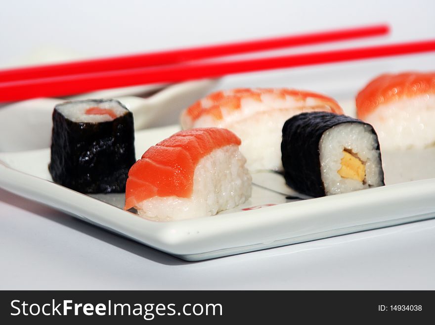 Sushi meal still-life with rice, fish and red chopsticks