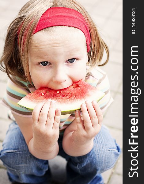 Girl squats and eats watermelon. Girl squats and eats watermelon