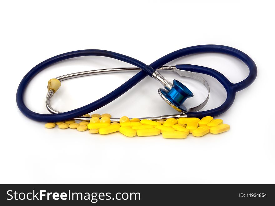 Stethoscope with pill against white background