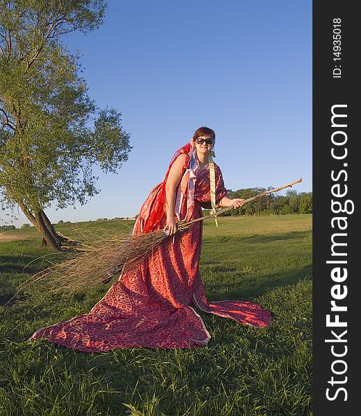 Witch in the open air holding a broom