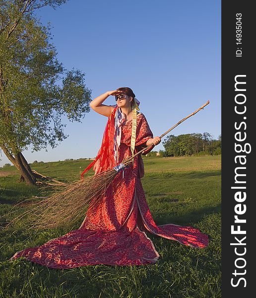 Witch in the open air holding a broom