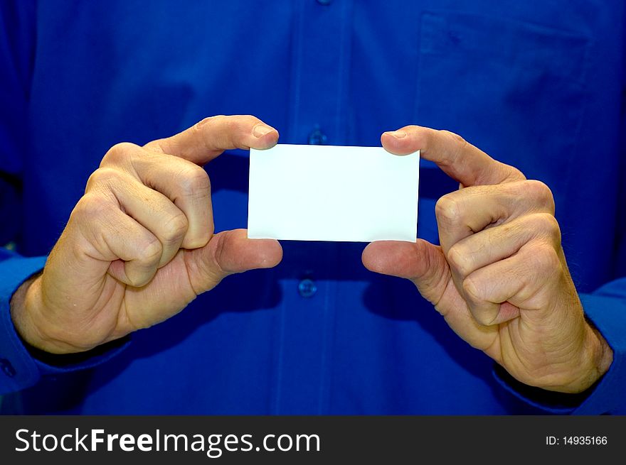 A man in a blue business shirt holding a blank business card. A man in a blue business shirt holding a blank business card