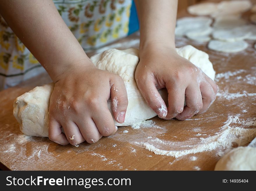 An image of hands making dough on the table