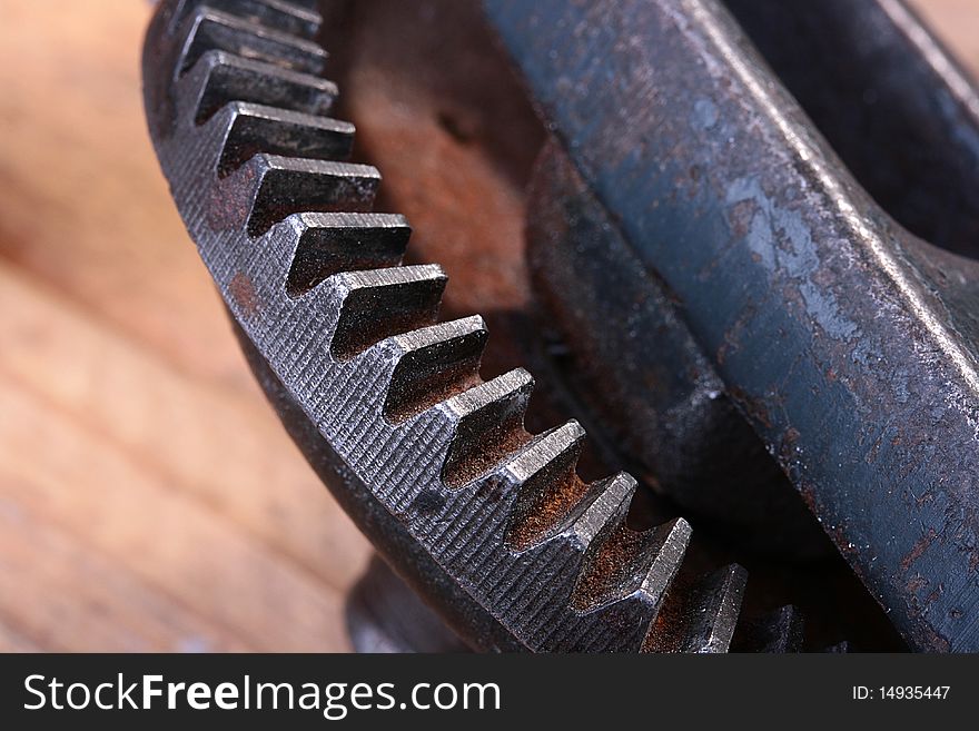 Old steel gear wheel on a wooden table. Old steel gear wheel on a wooden table.