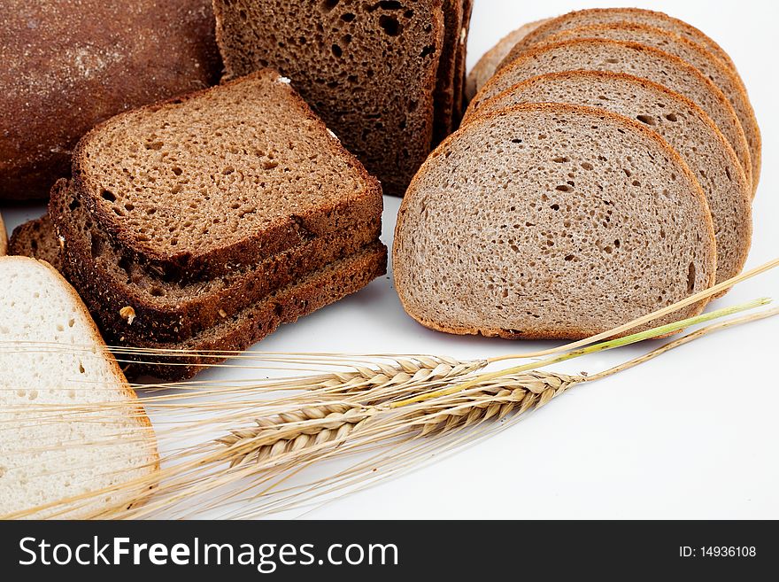 Various sorts of bread and spikes on white background
