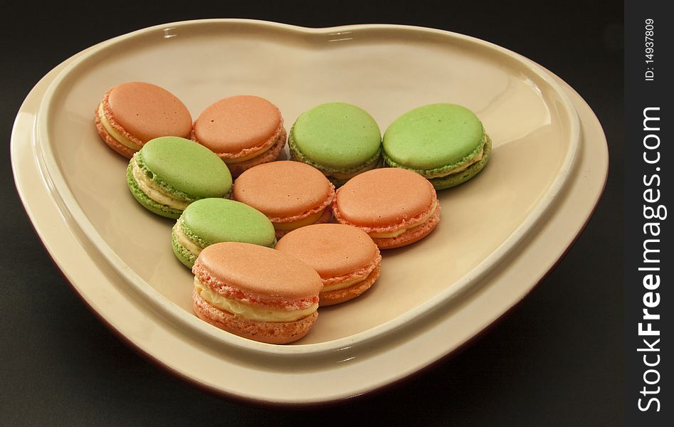 Ten French macarons on a heart shaped dish. Ten French macarons on a heart shaped dish