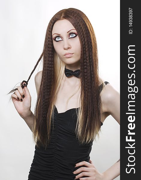 Elegant fashion model with dark make-up posing in studio