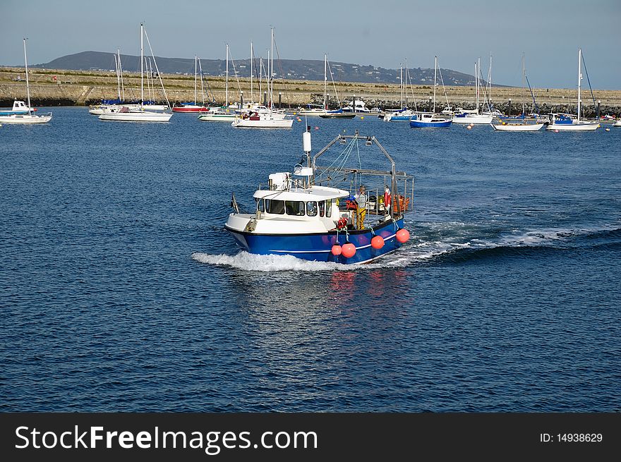 The small fishing boat against the yachts in the port. The small fishing boat against the yachts in the port