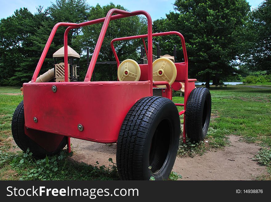 Rear and side of a playground machine resembling a Jeep made of welded metal tubes in a public park. Rear and side of a playground machine resembling a Jeep made of welded metal tubes in a public park.