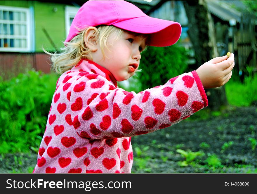 A Little Girl Handing A Berry