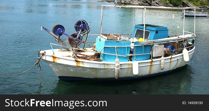 Old fishing boat on anchor in a port of Marmaras in Chalkidiki in Greece