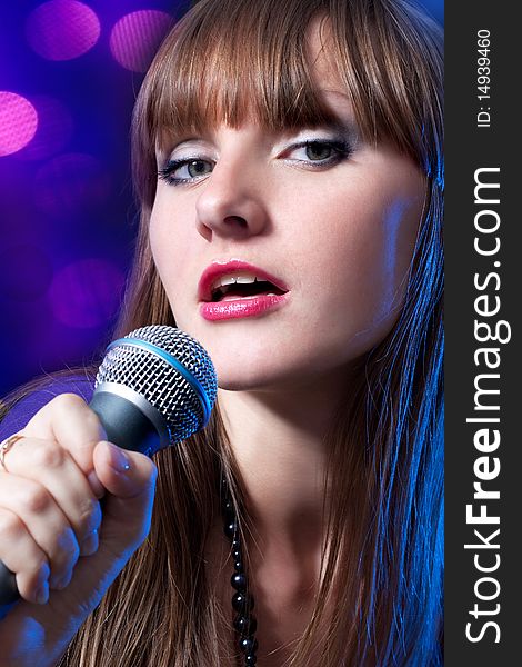 Portrait young Woman Singing into Microphone