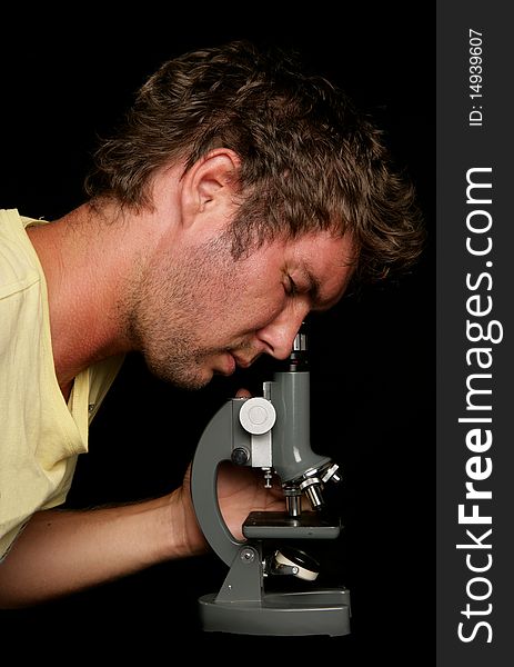 Man looking into microscope in studio